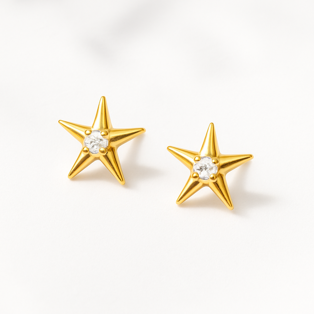 Gold star-shaped earrings with clear gemstones on a white background