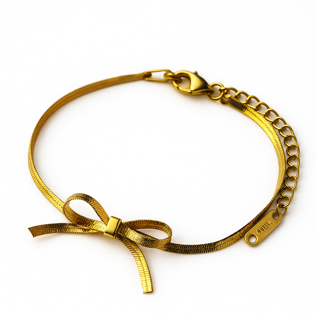Gold bracelet with bow detail on a white background