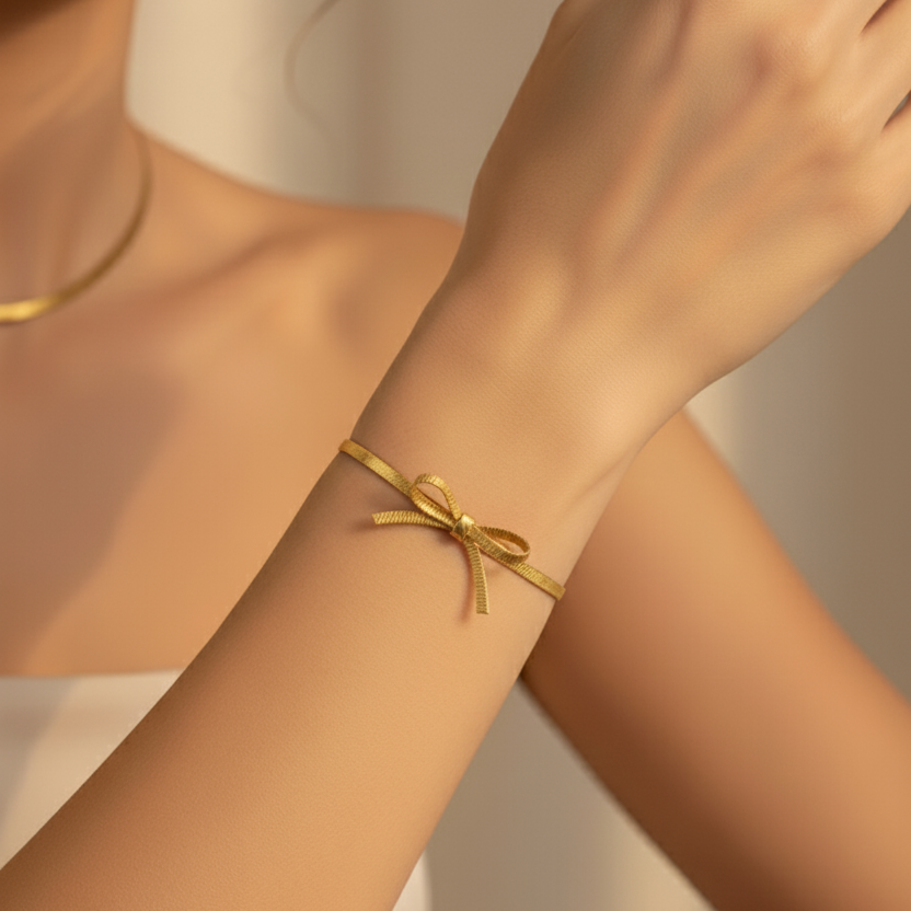 Gold bracelet on a person's wrist with a neutral background