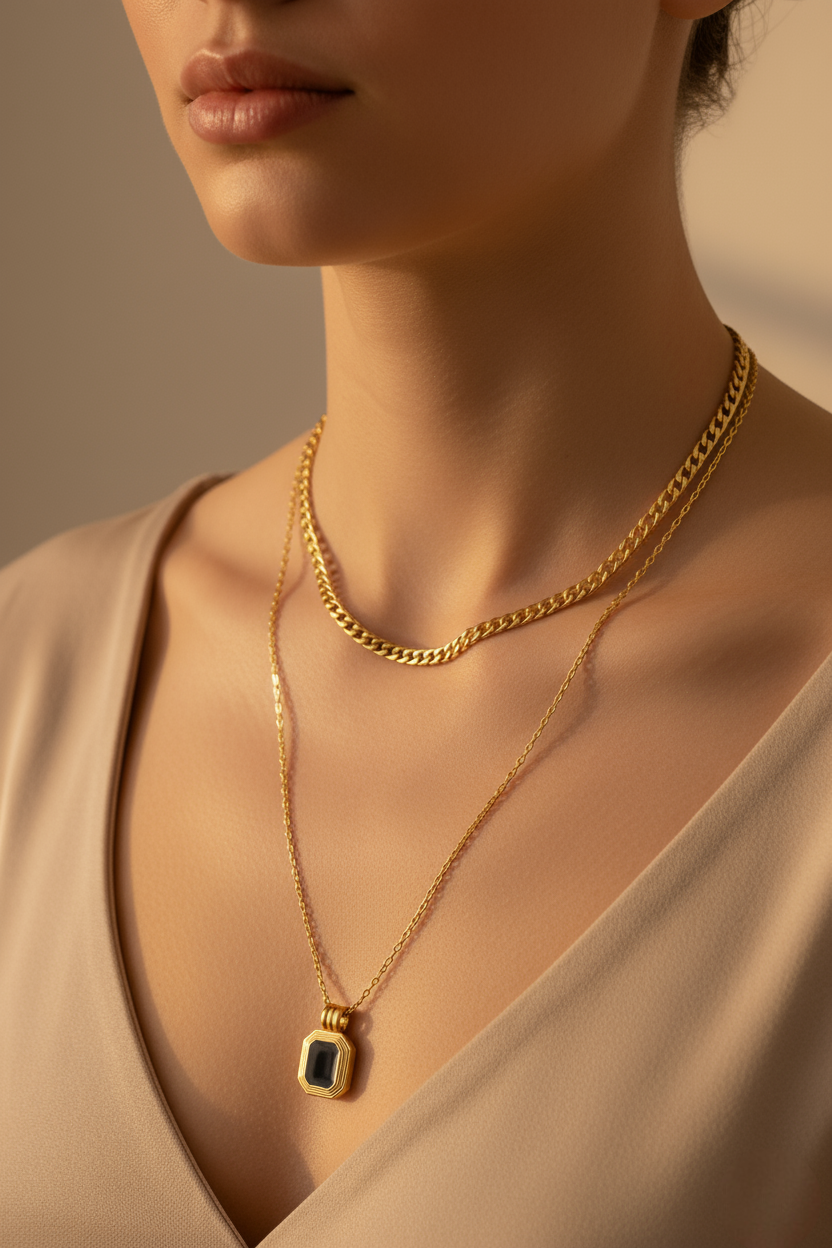 Close-up of a person wearing a gold chain necklace with a pendant.