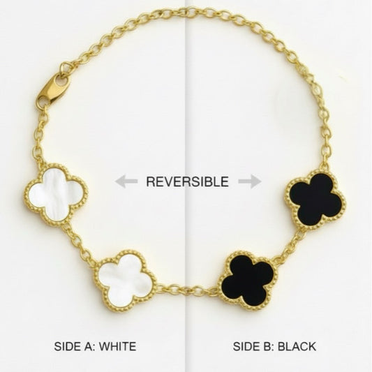 Reversible gold bracelet with white and black clover designs on a white background