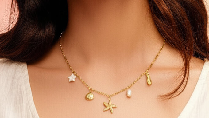 Woman wearing a gold necklace with starfish pendant against a pink background