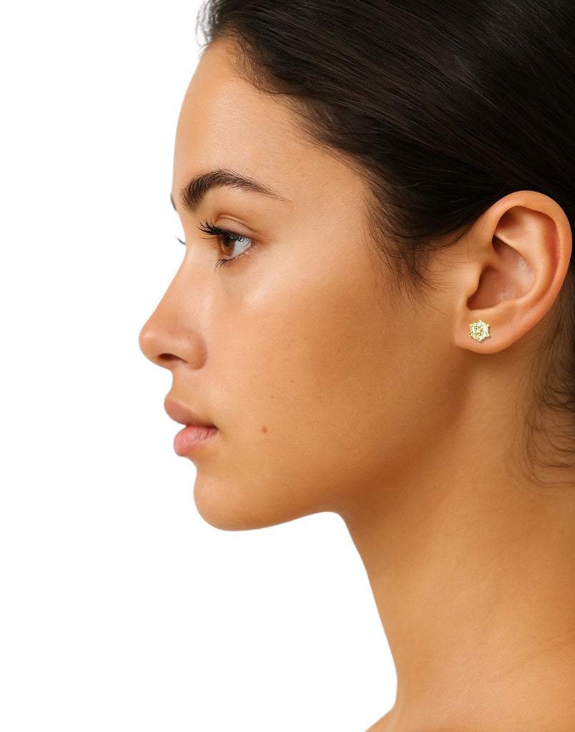 Close-up of a woman's ear wearing a CZ stone stud earring on a white background