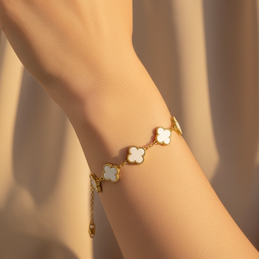 Gold bracelet with white stones on a wrist against a neutral background
